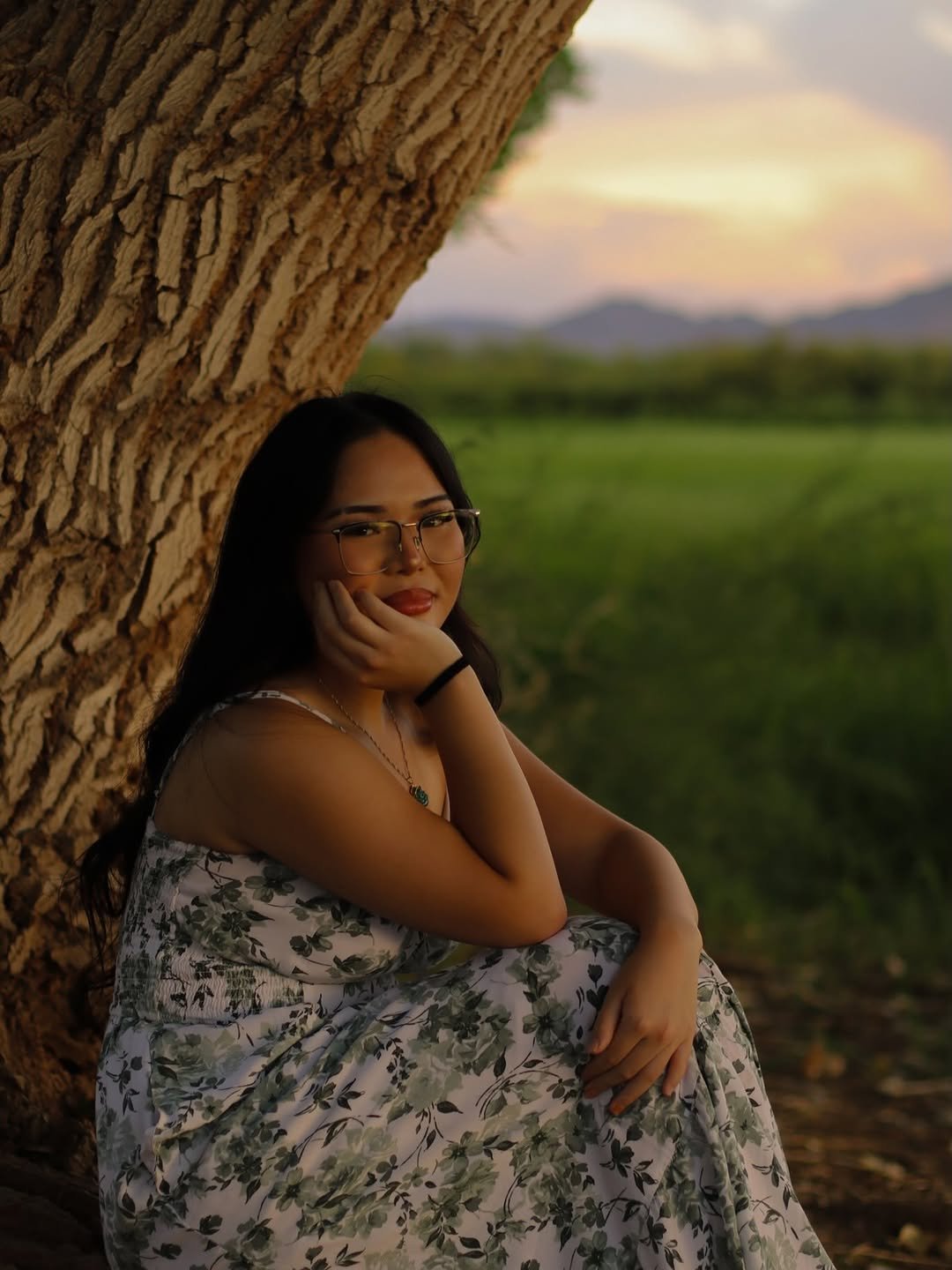 Portrait of a woman beneath a tree at sunset